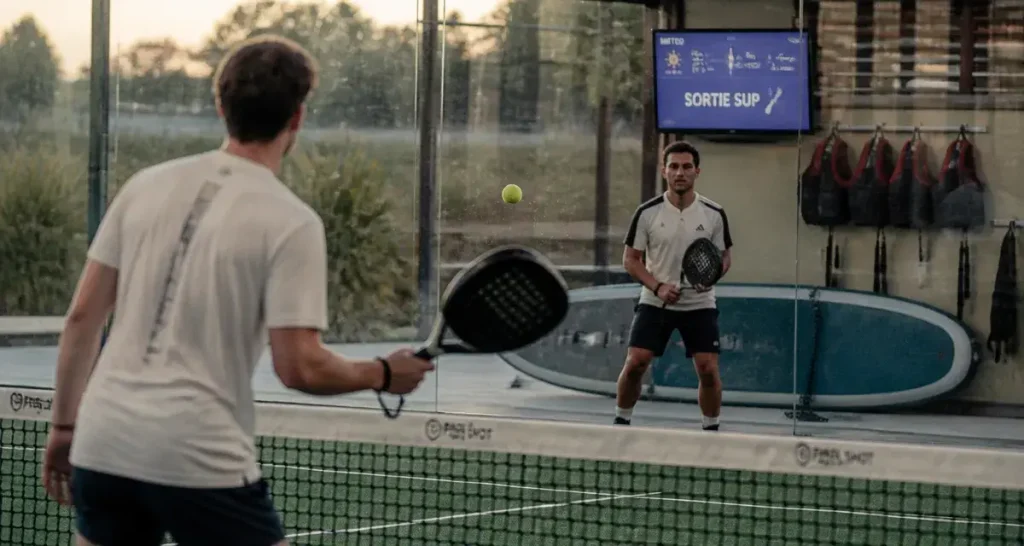 paddle montpellier : deux joueurs de padel sur court vitré près de Montpellier